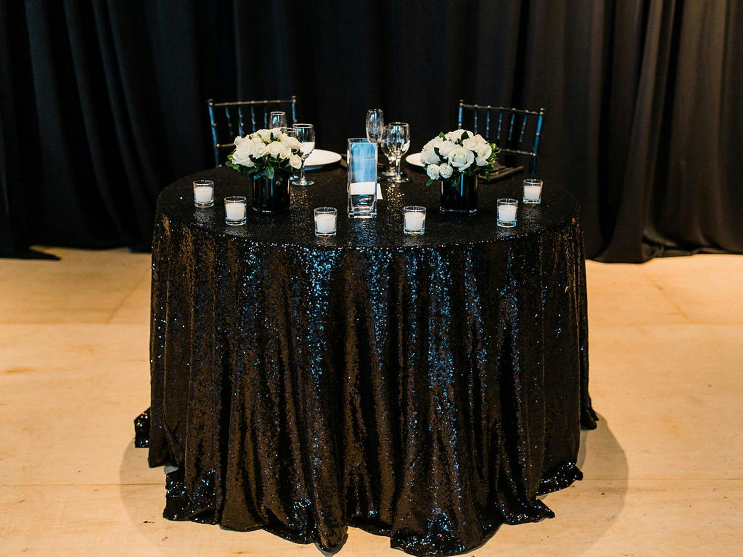 Wedding Sweetheart Table With Glittery Black Linen and White Flowers | PartySlate