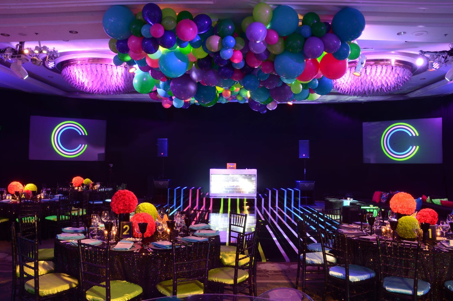 Neon Bar Mitzvah Party with Striped Neon Dance Floor and Colorful Ceiling Balloon Décor | PartySlate