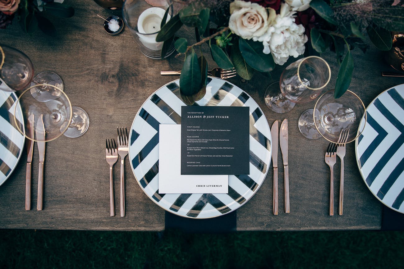 Black and white striped plate design with gold utensils for a modern wedding | PartySlate