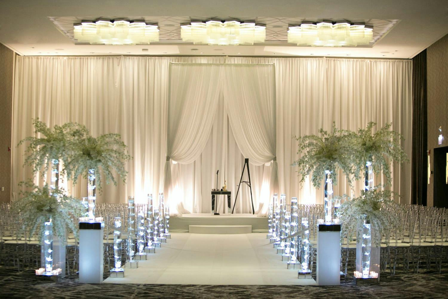 Modern Wedding Ceremony With White Drapery Backdrop and Candlelit Aisle Markers | PartySlate