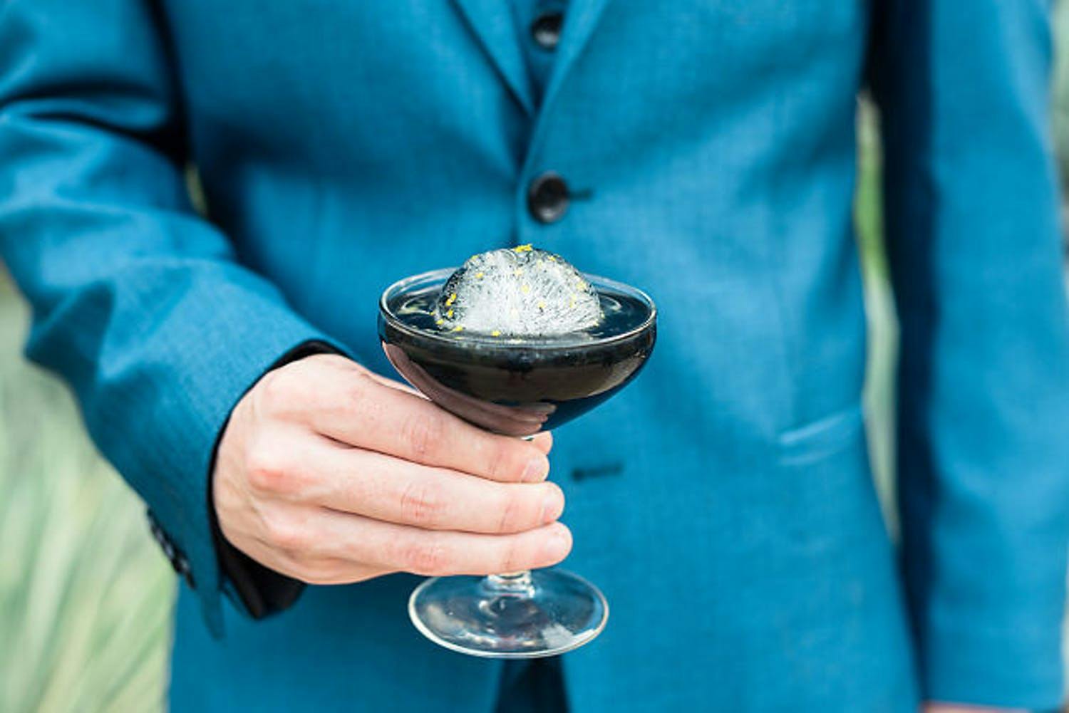 Man in Blue Jacket Holds a Modern Black Cocktail at Wedding | PartySlate