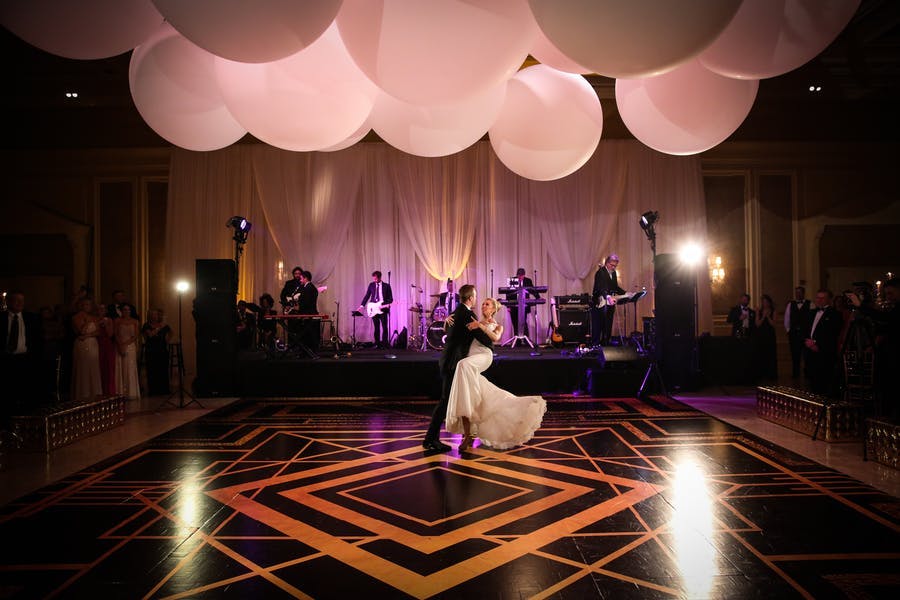 Deco designed gold and black wedding dance floor | PartySlate