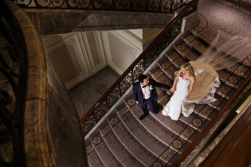 Groom Lead Bride Walking Down Stairs | PartySlate