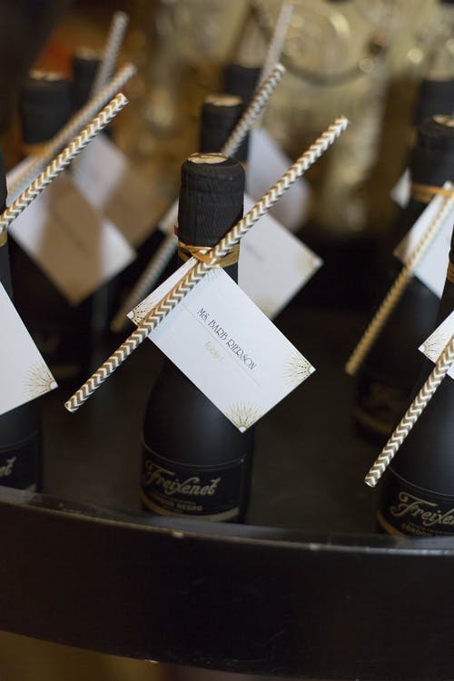Mini black champagne bottles with table numbers | PartySlate