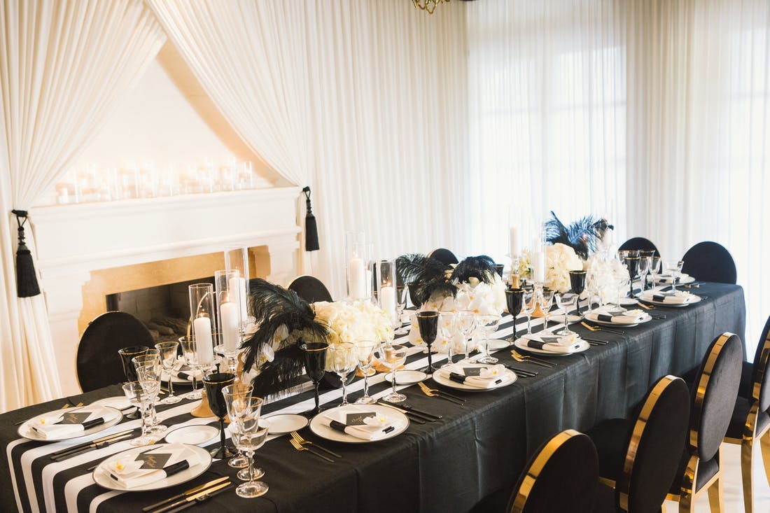 Black and white lined table with gold detail and black and white feathers, Gatsby theme | PartySlate