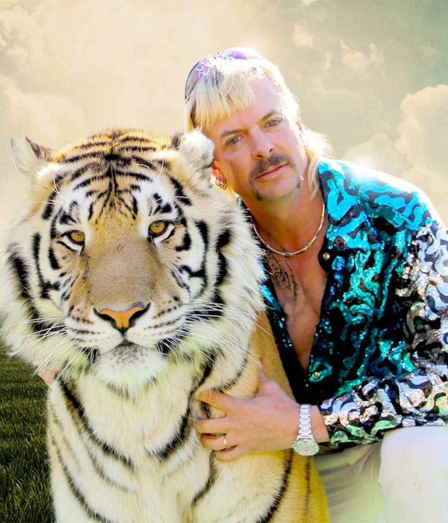 Joe Exotic from Netflix's Tiger King posing with a large Tiger