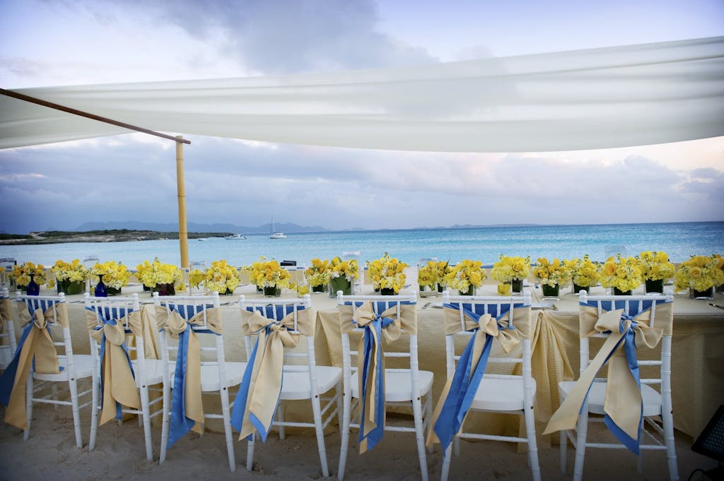Beach Wedding With Reception Table Beneath Suspended Drapery | PartySlate
