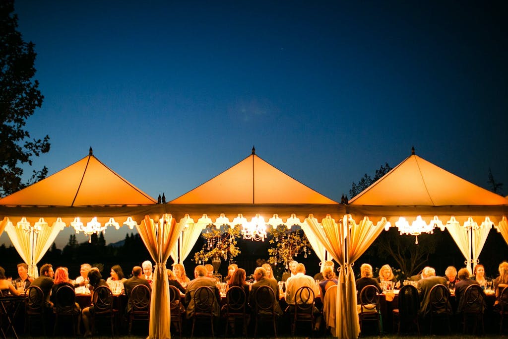 Three Connected Marquee Wedding Tents Illuminated at Night | PartySlate