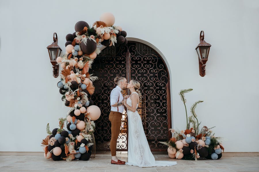 A micro wedding with beautiful balloon installation with pinks and dark colors | PartySlate