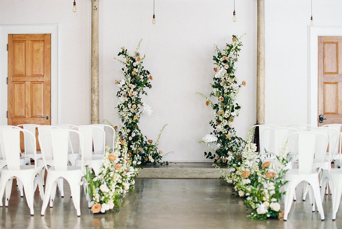 Monochrome micro wedding with white walls and chairs and greenery | PartySlate