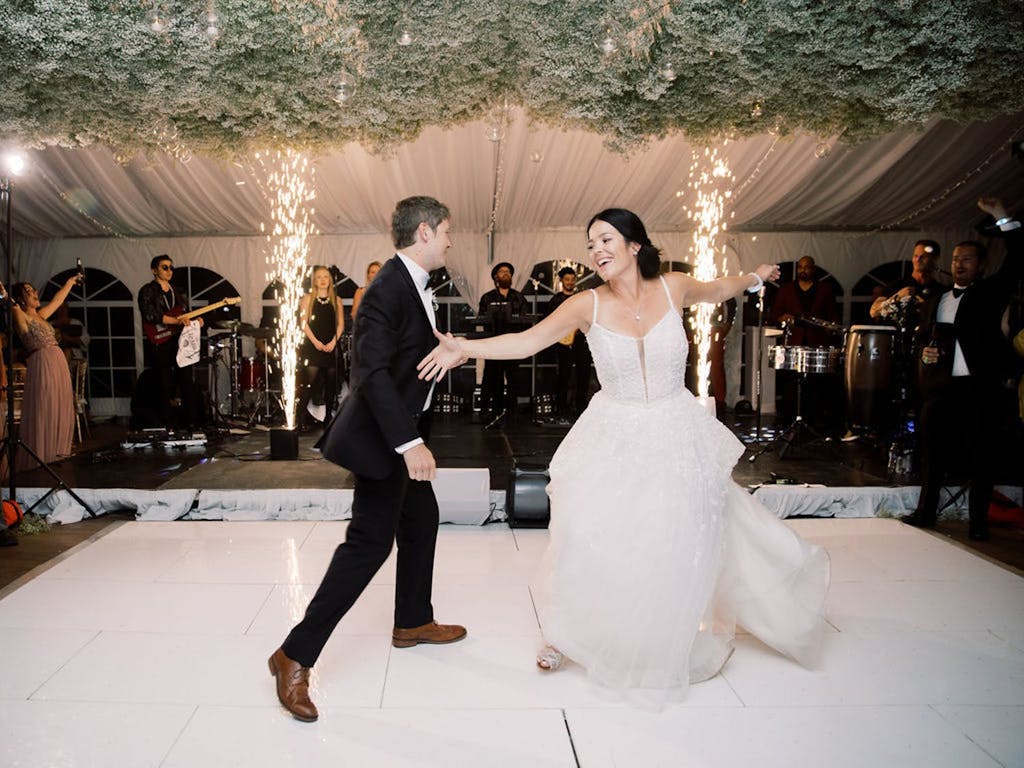 Couple Dance in White Wedding Tent With Baby's Breath Ceiling installation | PartySlate