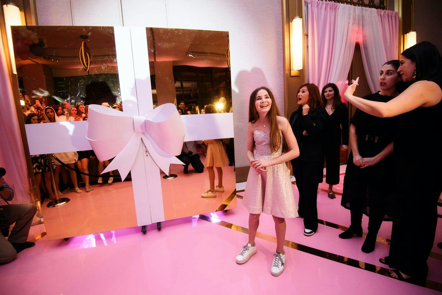 Interactive Dessert Station Behind Two Gold Doors Wrapped in a Pink Bow at Pink-Themed Bat Mitzvah Party | PartySlate