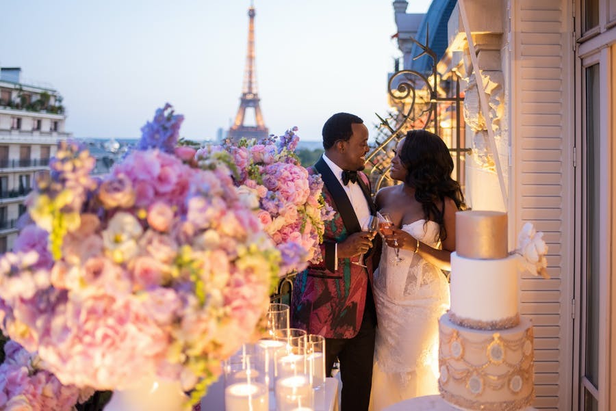 Balcony image of bride and groom with a view of the Eiffel Tower | PartySlate