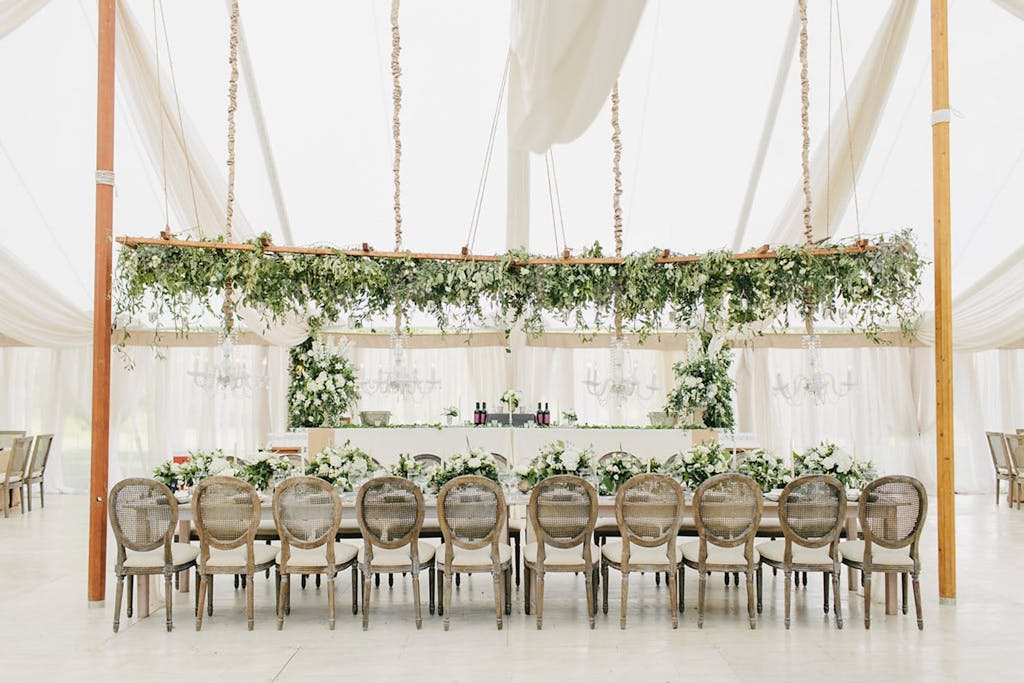 Ethereal White Canopy Wedding Tent With Elevated Greenery Centerpieces | PartySlate