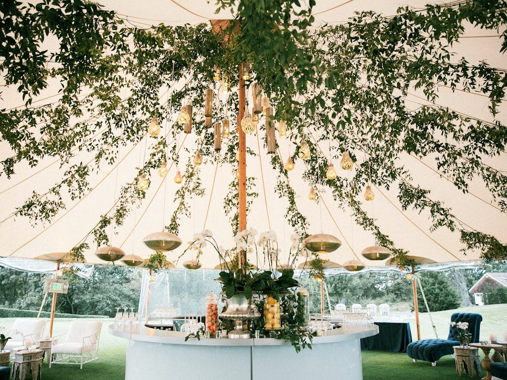 Pole Tent Wedding With Roof of Lavish Greenery | PartySlate