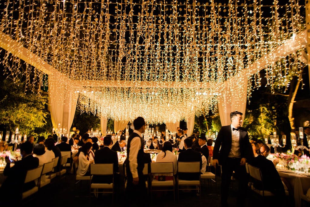 Outdoor Nighttime Wedding Reception with Open Tent Structure With String Lights | PartySlate
