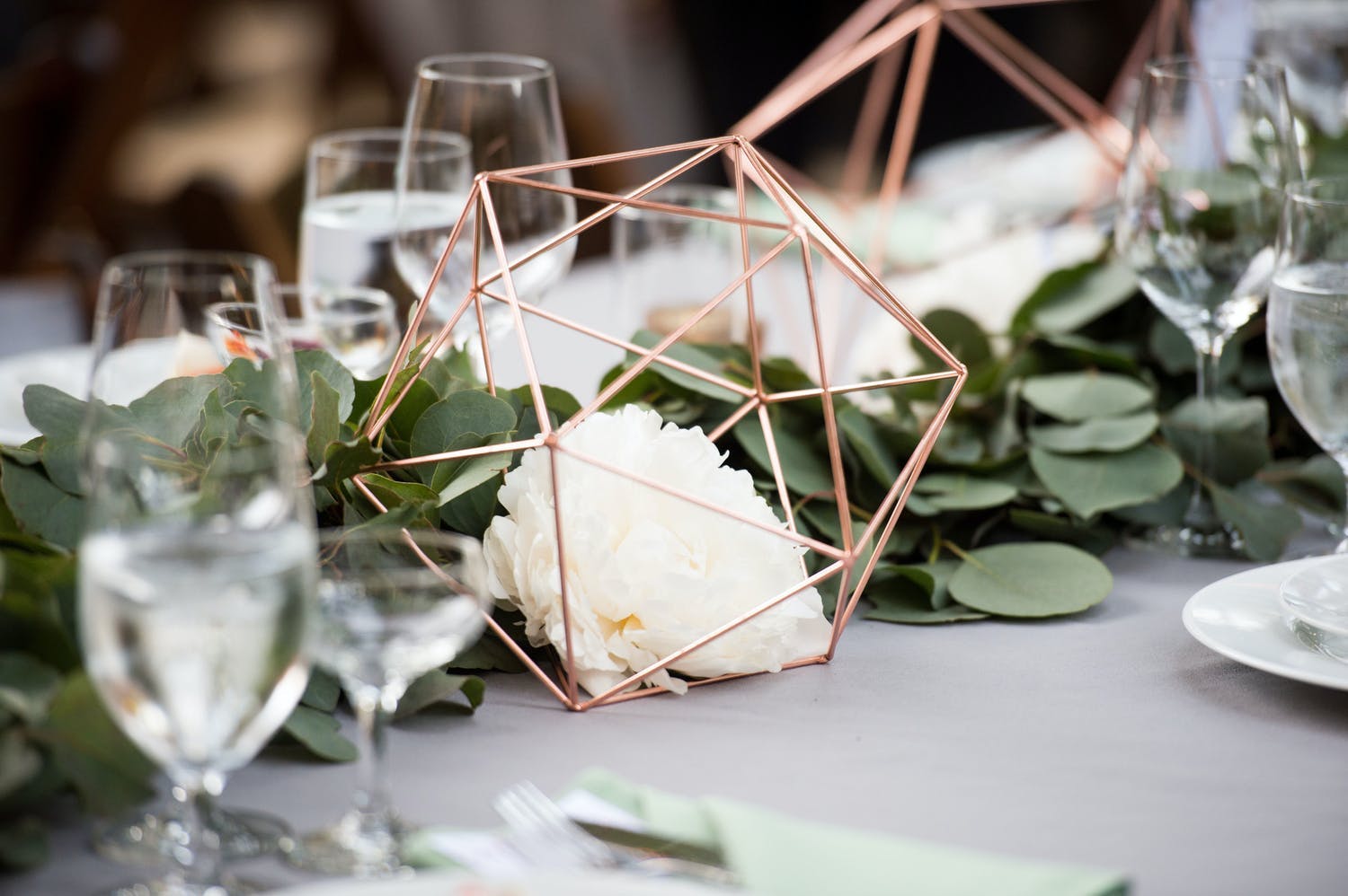 Rustic Wedding Centerpieces With Greenery Garland and Copper Geometric Structures | PartySlate