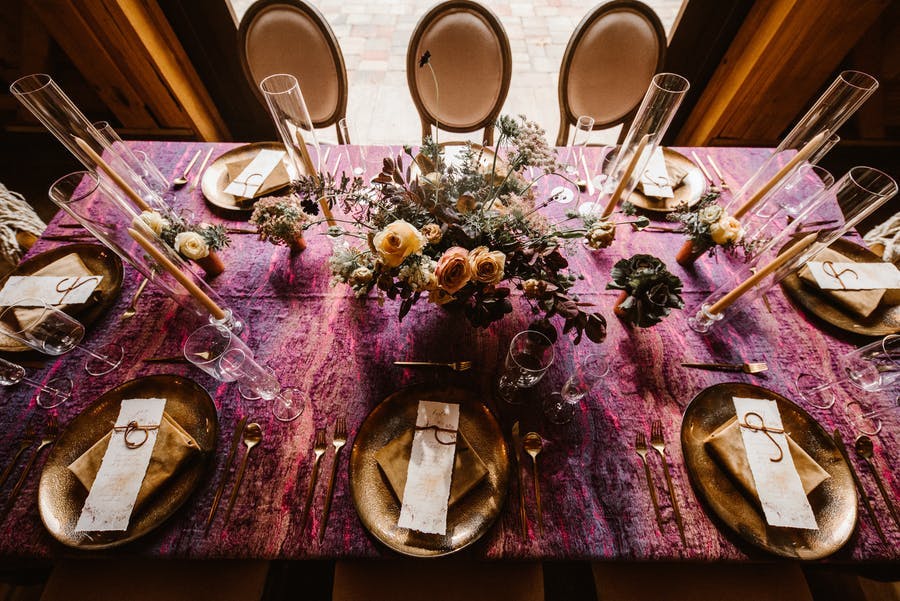 Rustic purple table cloth at a micro wedding with beautiful florals and gold vintage detail | PartySlate