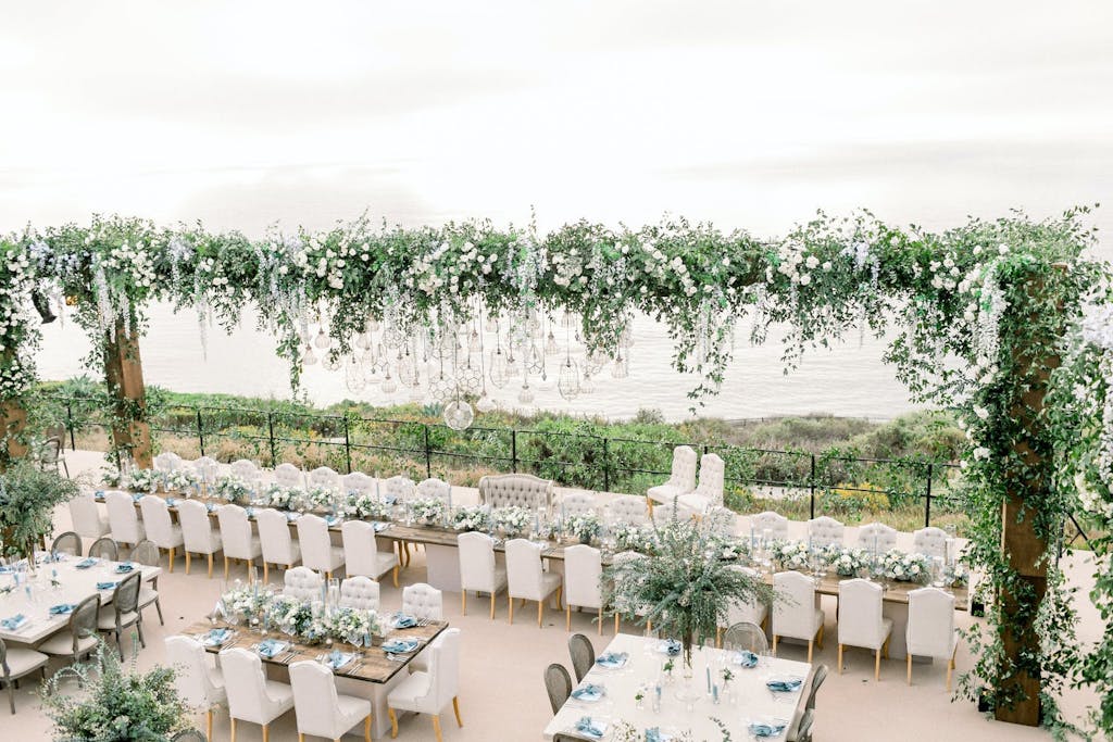 A garden-like wedding reception with lots of greenery and florals.