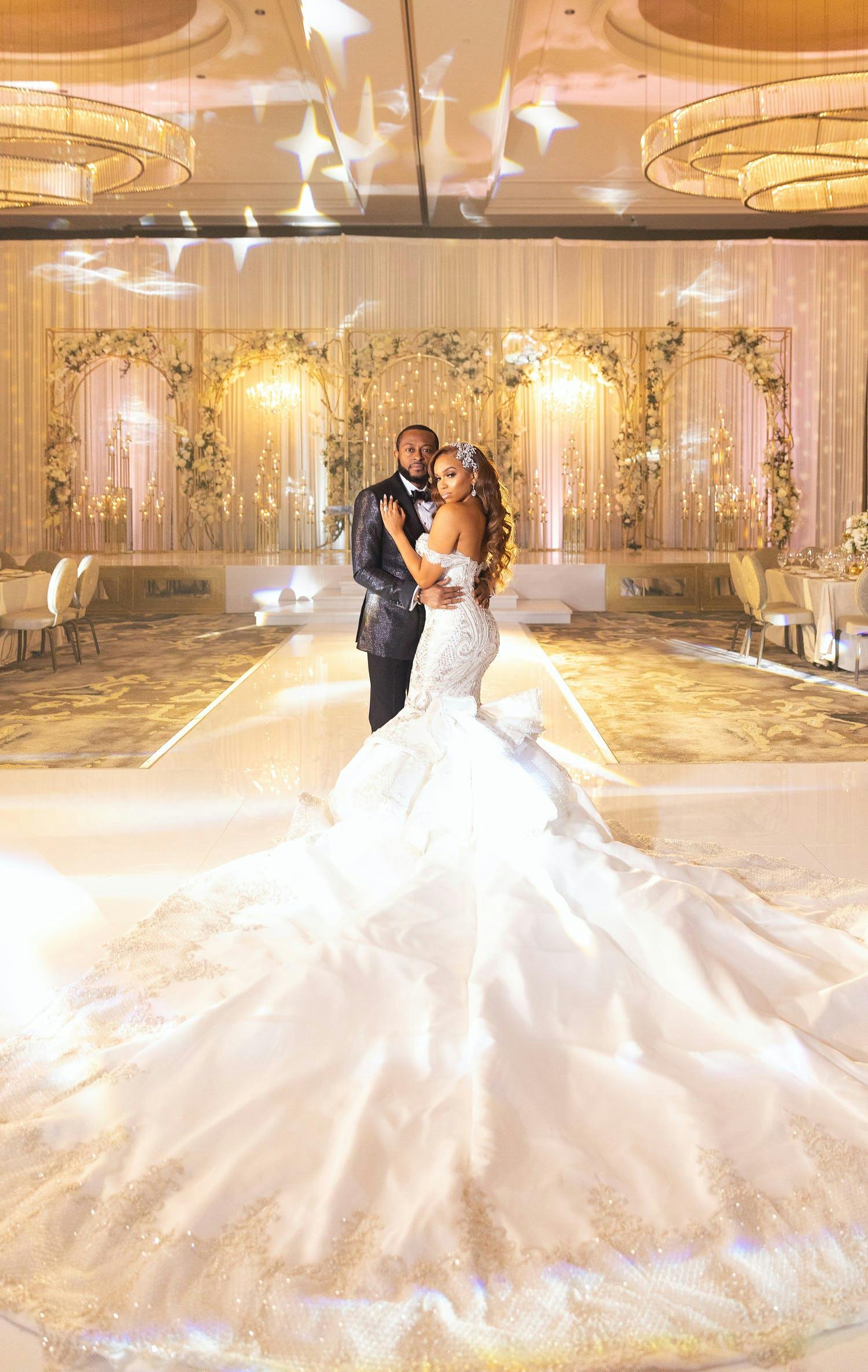 Bride and Groom Embrace at Golden Ballroom Wedding | PartySlate