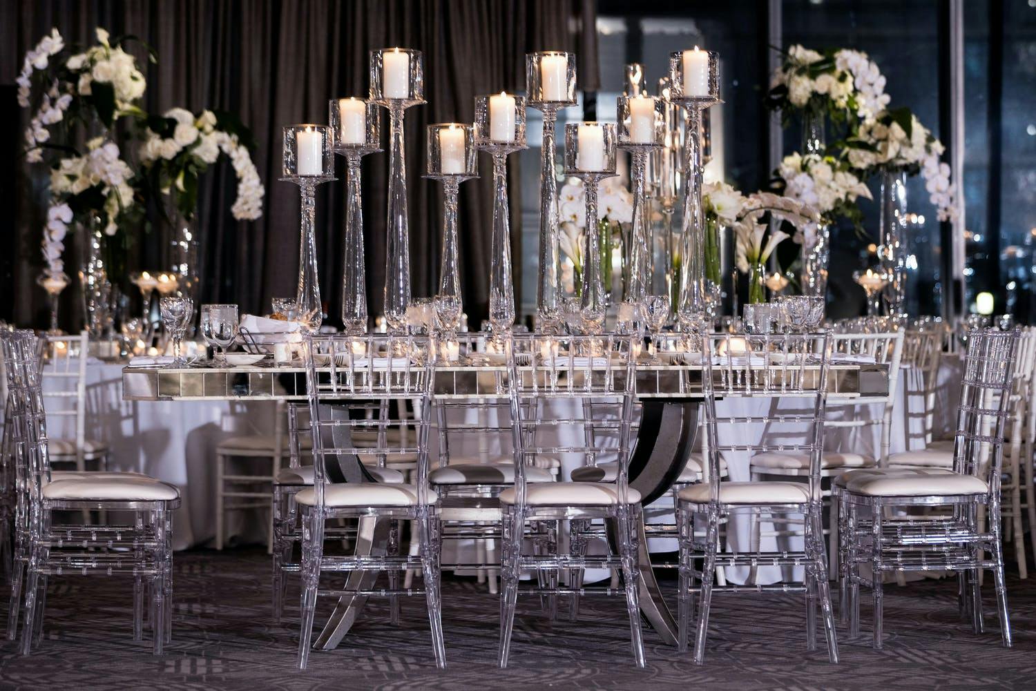 Wedding Tablescape With Lucite Seating and Towering Glass Candleholders | PartySlate