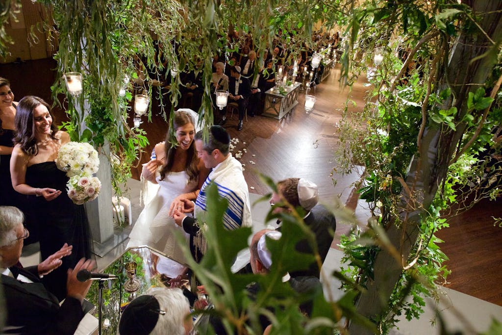 Wedding Ceremony Seen Through the Branches of the Chuppah | PartySlate