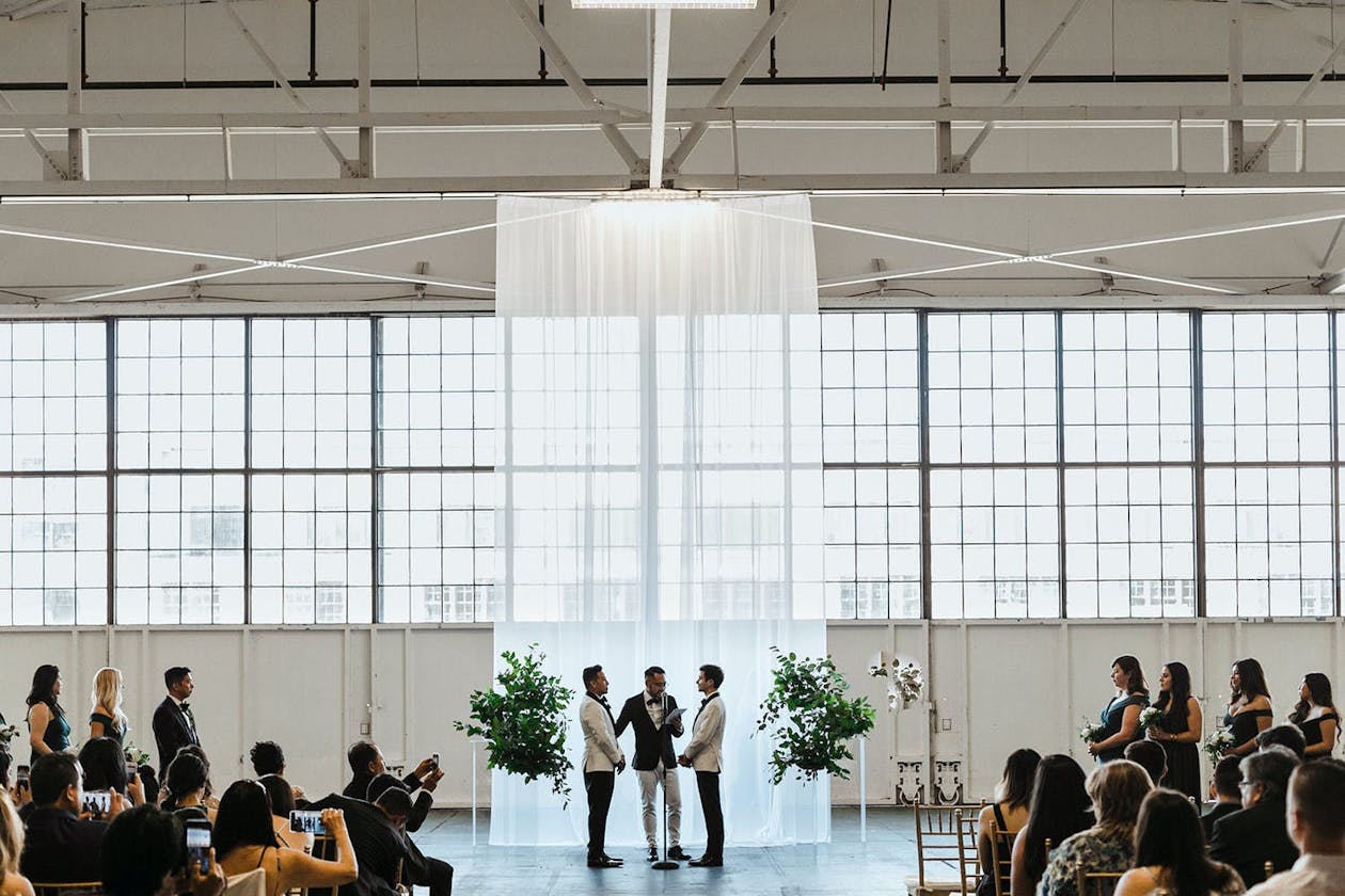 Wedding Ceremony With Modern Wedding Décor and Shimmering Drapery Backdrop | PartySlate