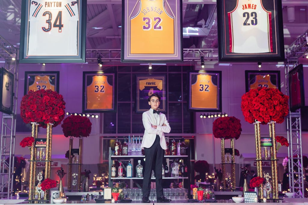A Bar Mitzvah boy standing in front of iconic basketball jerseys.