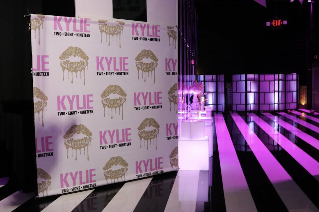 Gold Kiss Step and Repeat and Black and White Dance Floor With Pink Uplighting at Sweet 16 Party | PartySlate