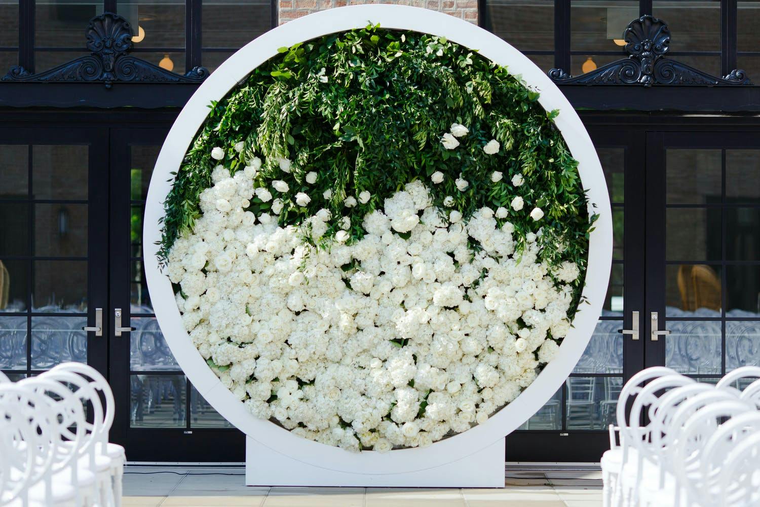 Modern Circular Wedding Arch Filled With Half Greenery and Half White Flowers | PartySlate