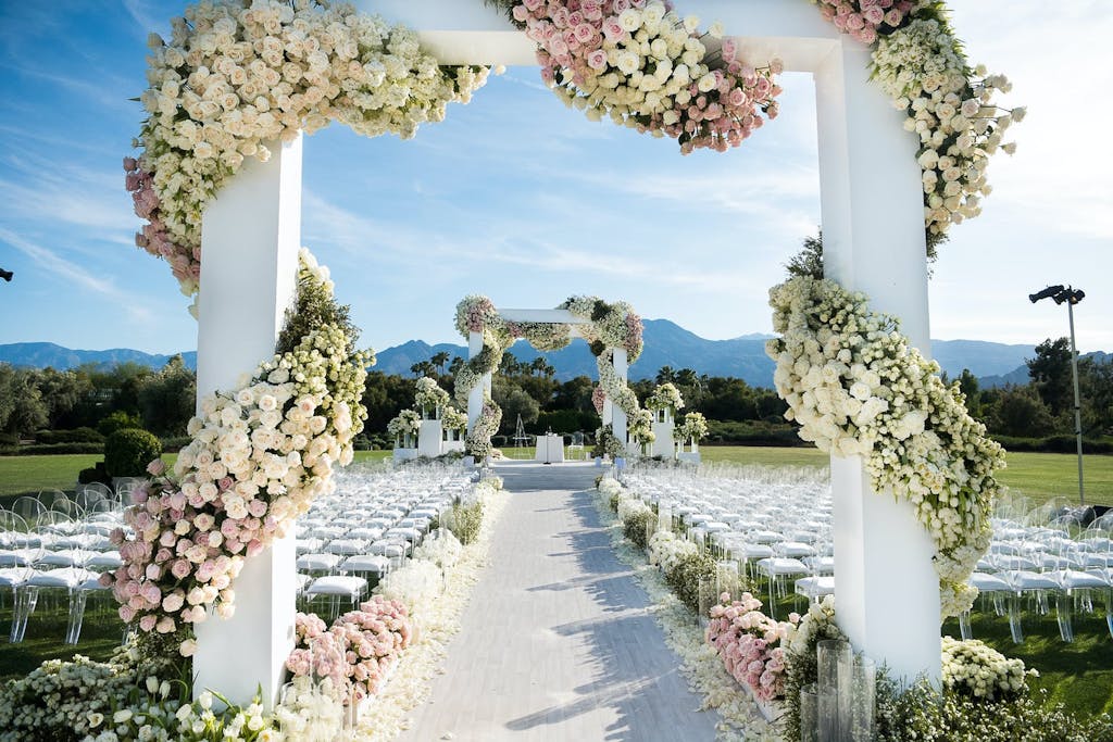 Wedding ceremony décor with florals wrapped around the aisle archways.