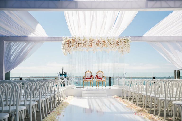 White beach side wedding with white linings and florals | PartySlate