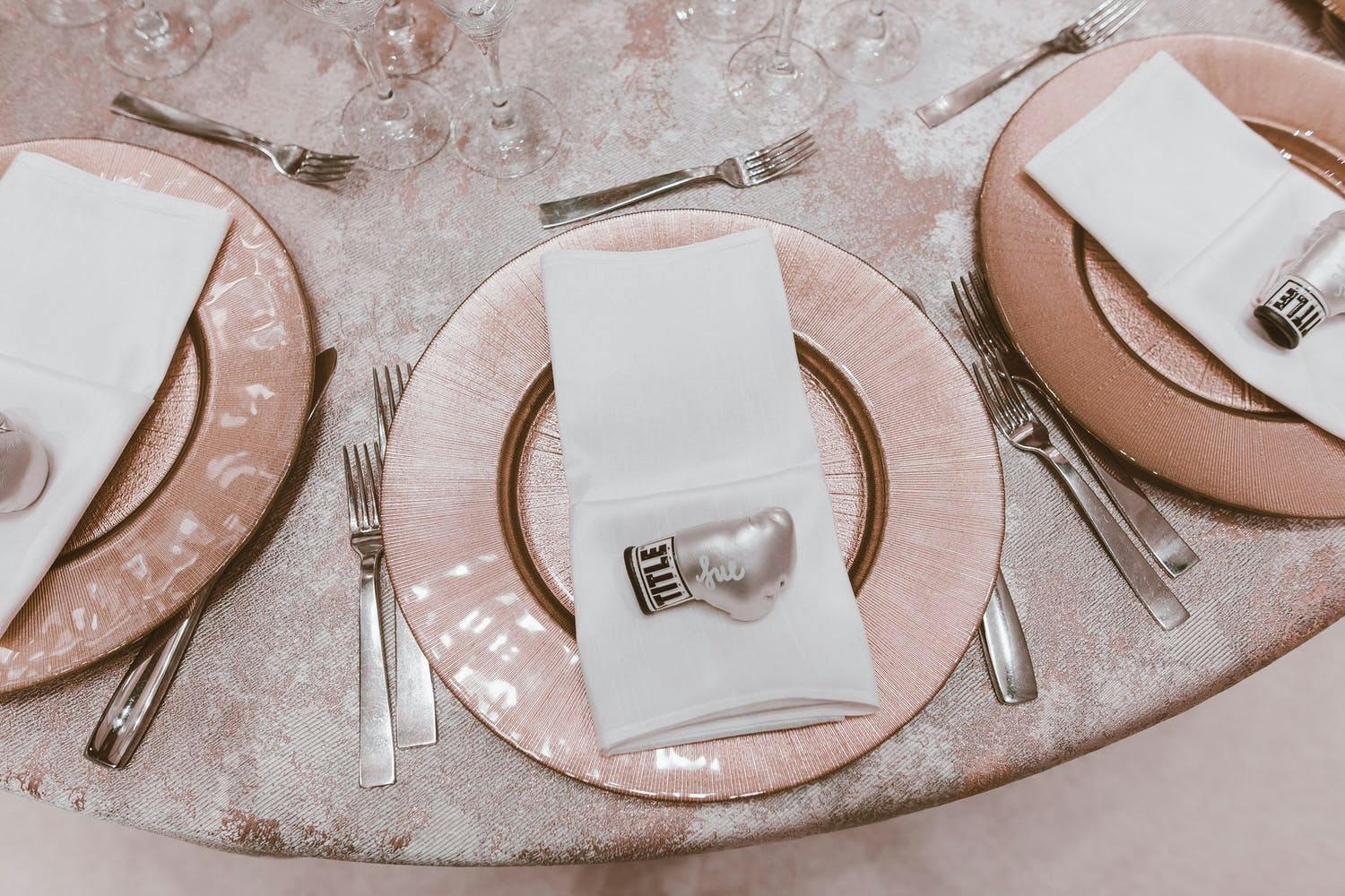 Shimmering Pink Wedding Tablescape With Personalized Mini Pink Boxing Glove Trinket on Each Plate | PartySlate