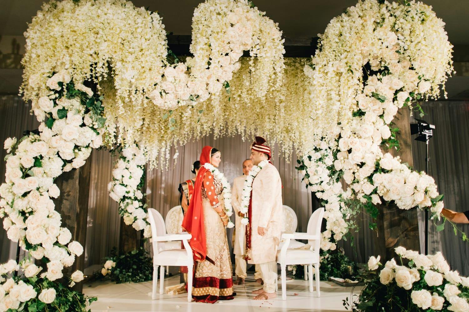 Mandap With Swirling Hand-Opened Roses and Hanging White Wisteria | PartySlate