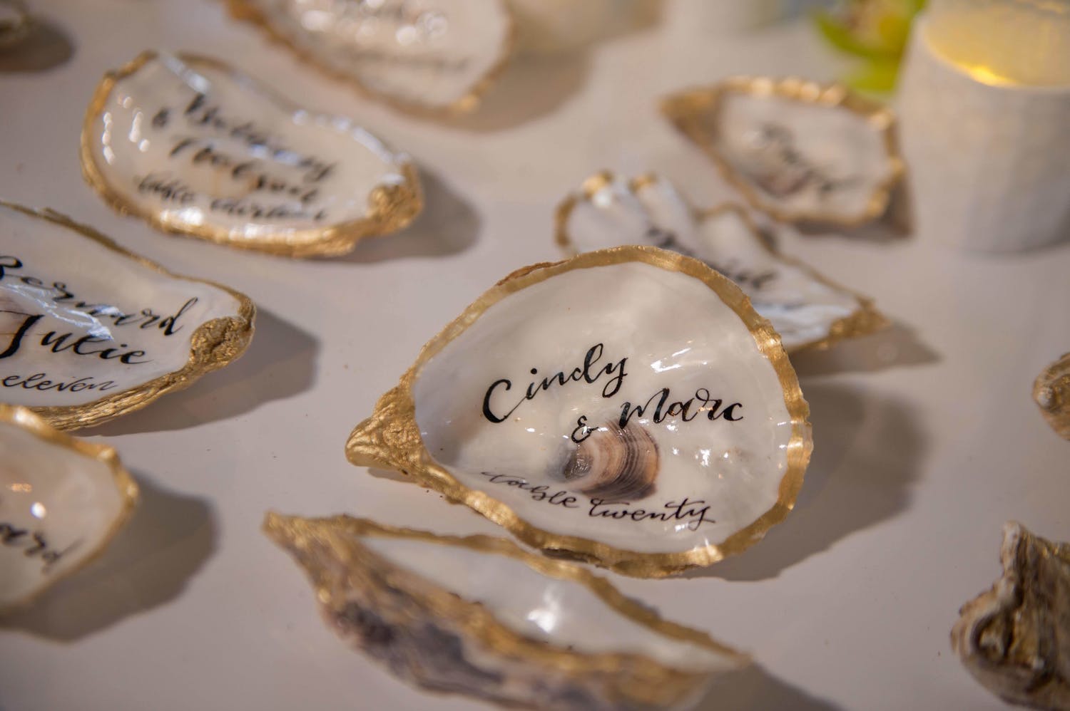 Table of Golden-Edged Oysters Inscribed With a Name and Wedding Table Number | PartySlate