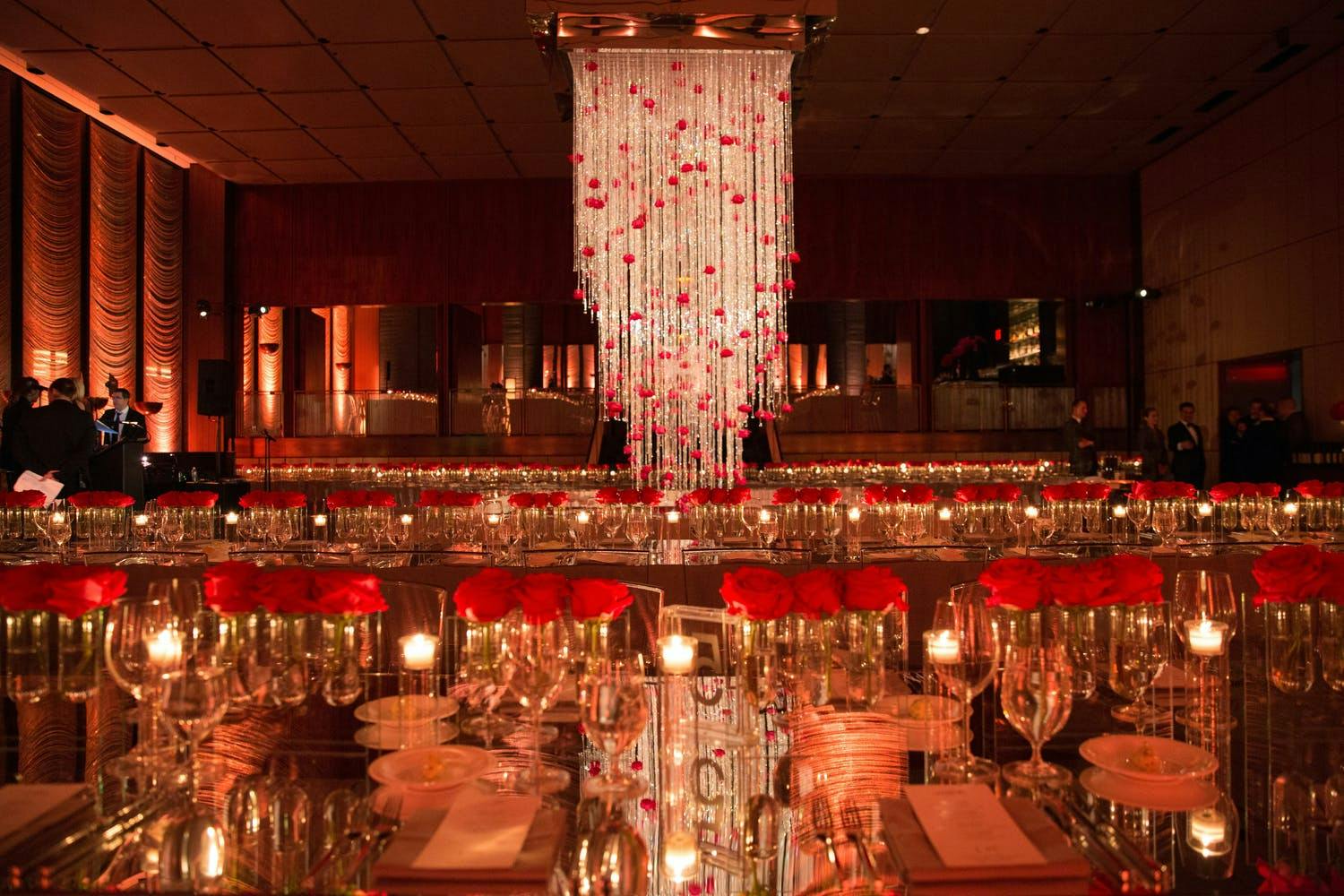 Ballroom Wedding With Waterfall Chandelier Woven with Red Roses and Red Rose Table Decorations | PartySlate