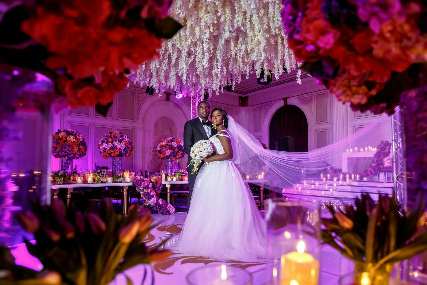 Ceiling of Suspended White Flowers With Red Rose Centerpieces in Foreground | PartySlate