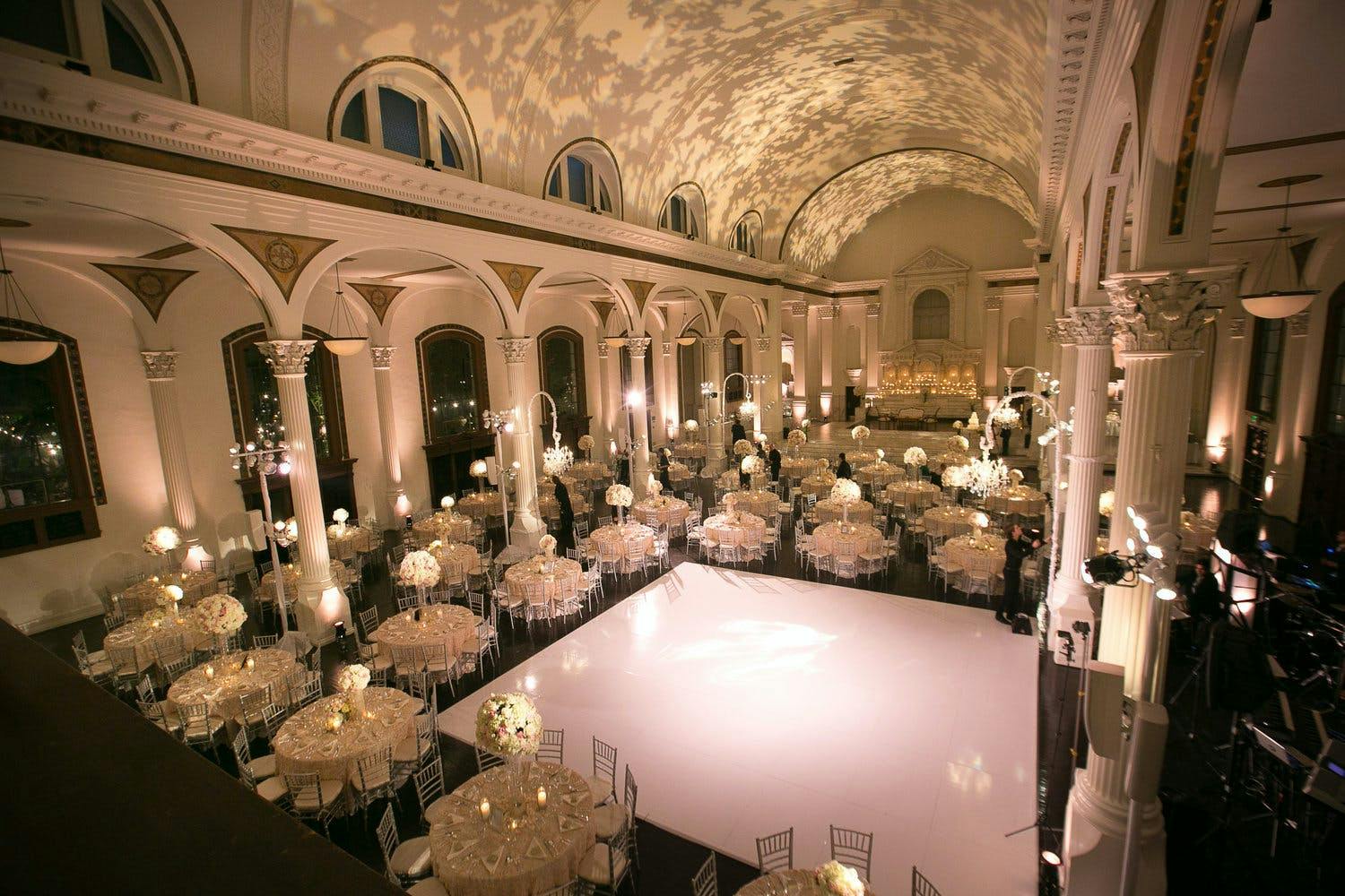 Wedding at Vibiana in Los Angeles With Dappled Tree Leaf Projections on Ceiling and Pearly White Dance Floor | PartySlate