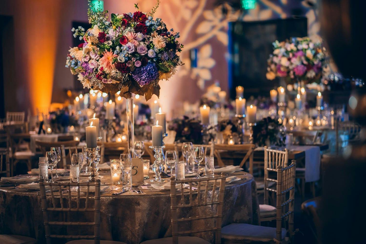 Tall Wedding Floral Centerpiece With Floral Lighting Projection in Backdrop | PartySlate