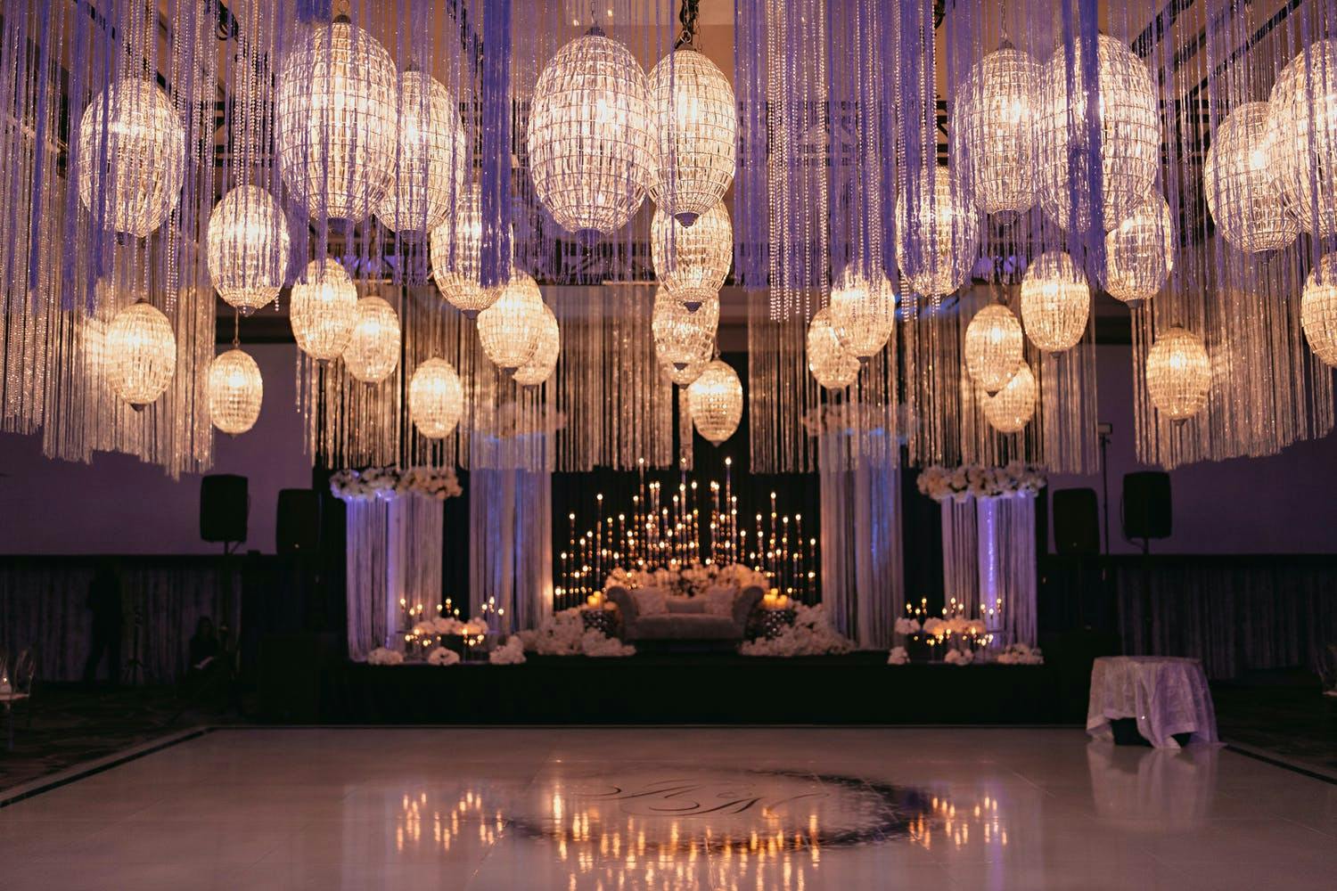 Wedding Ceiling Installation of Glass Orbed Chandeliers and Suspended Fringe and Crystal Tassels | PartySlate
