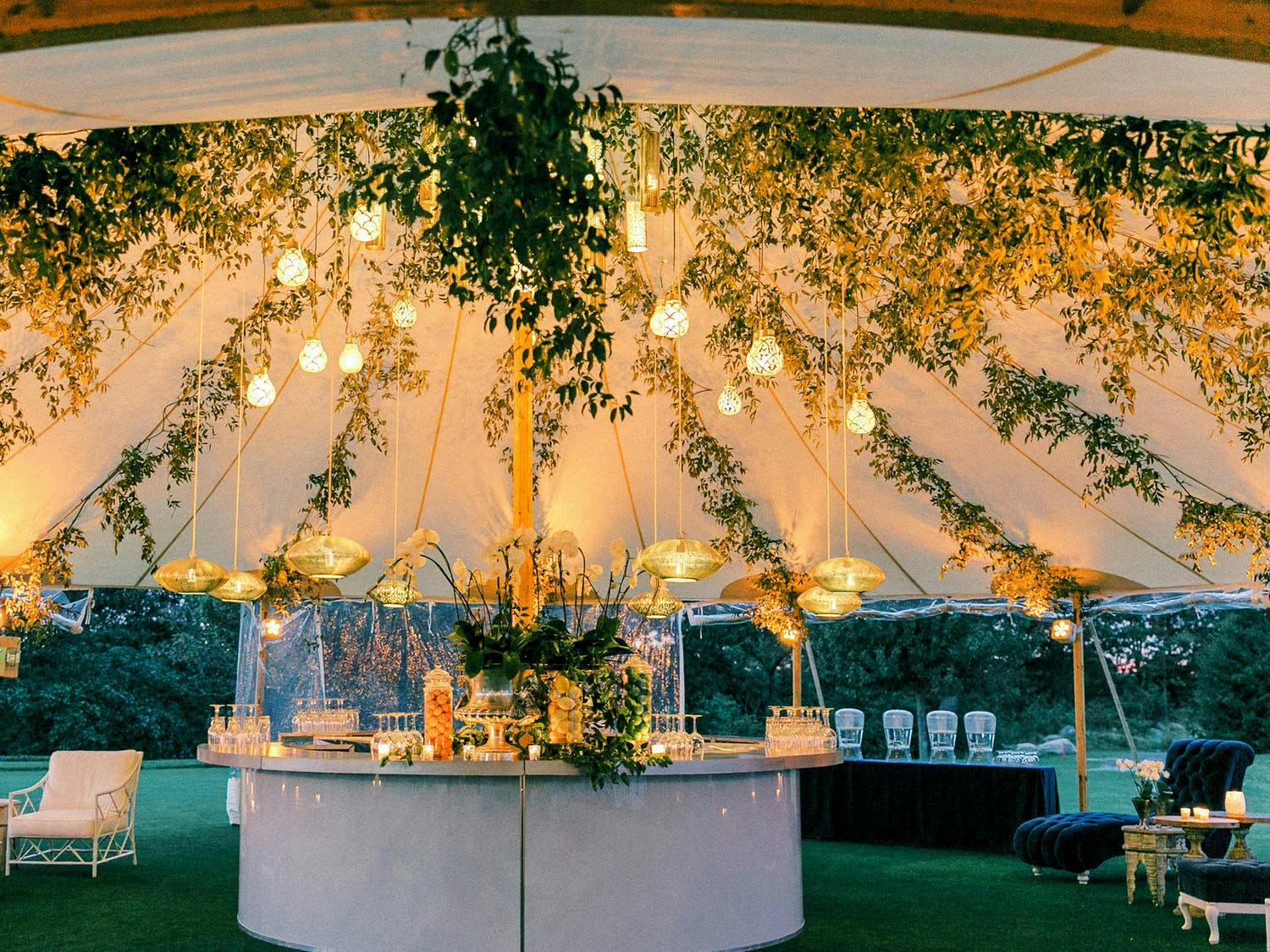 Wedding Pole Tent With Greenery and Two Levels of Suspended Chandelier Light | PartySlate