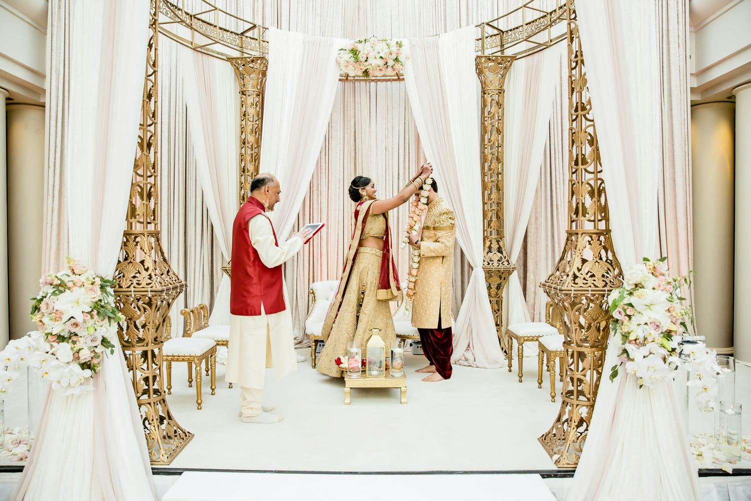 Mandap With Elegant Gold Pillars and Dreamy Pink Drapery | PartySlate