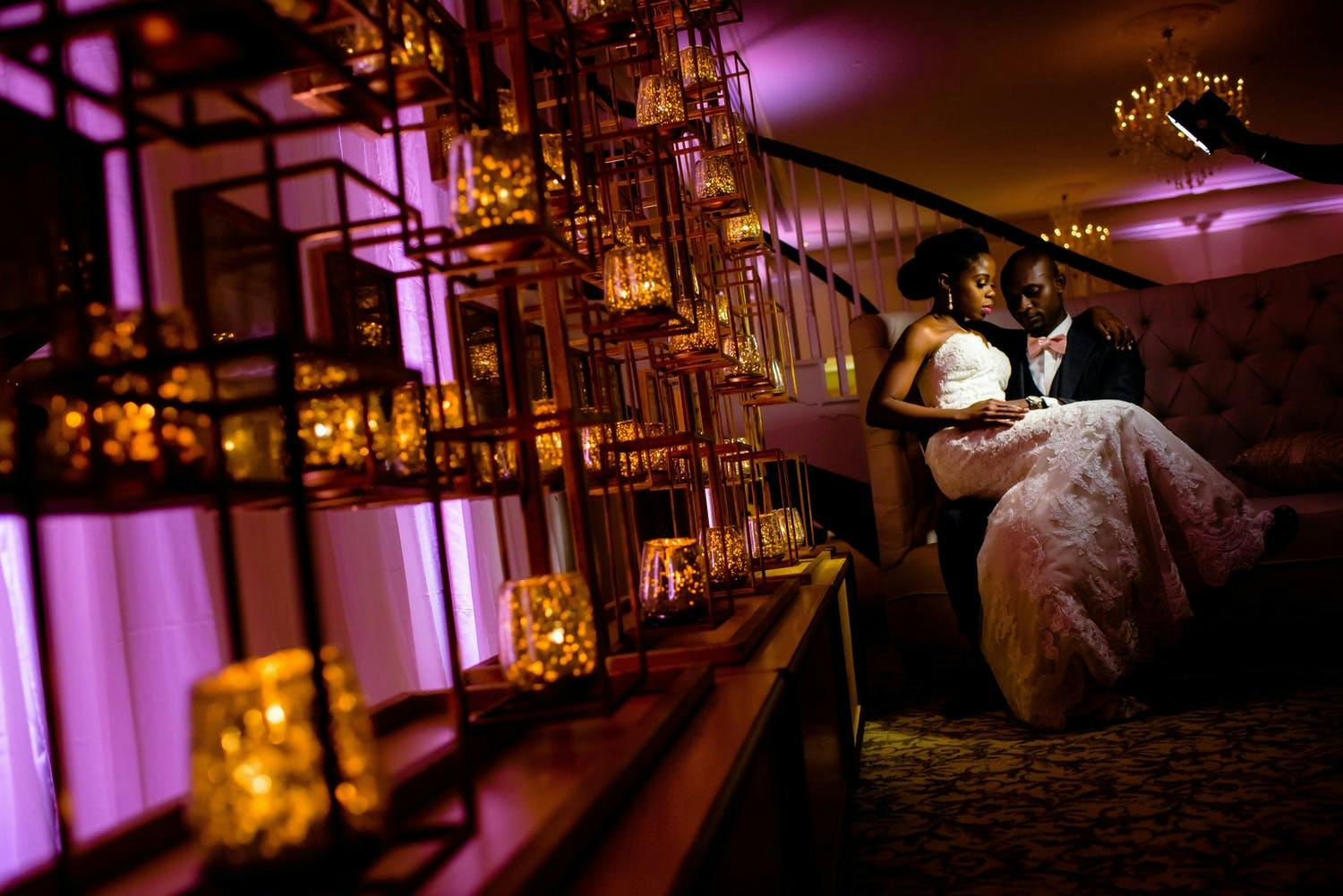 Wedding With Open Shelving With Amber Candles Against Purple Uplit Wall