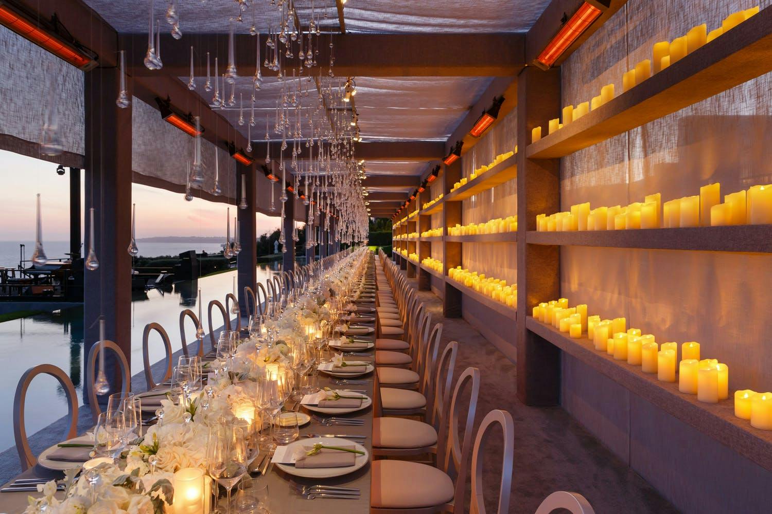 Seaside Wedding Canopy With One Wall Lined With Three Rows of Golden Candles | PartySlate