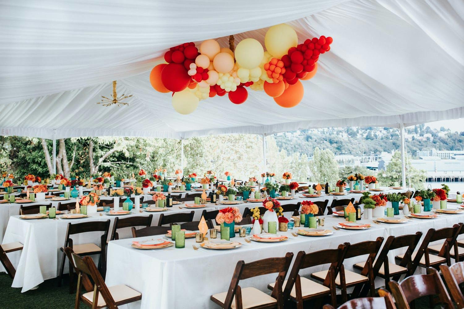Colorful Blooms “Pop” Against White Tablescapes (Beneath a Sunrise-Bright Balloon Installation) | PartySlate