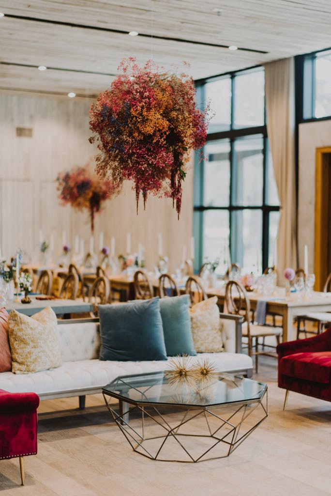 Eclectic and Colorful Wedding Reception Area With Colorful Baby’s Breath Ceiling Installation | PartySlate