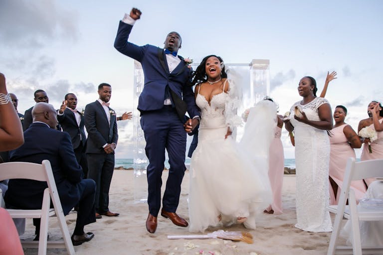 Bride and Groom Celebrate on Sandy Aisle After Oceanfront Exchange of Vows at The Palms Hotel & Spa | PartySlate
