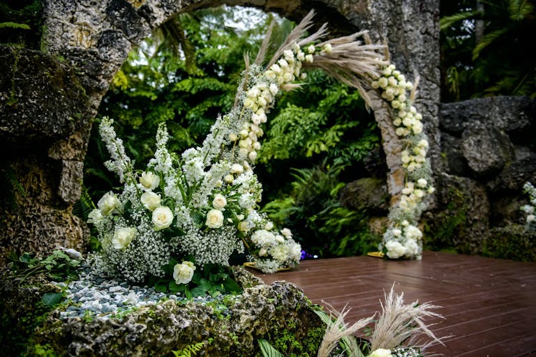 White Circular Wedding Arch With Lush Greenery | PartySlate