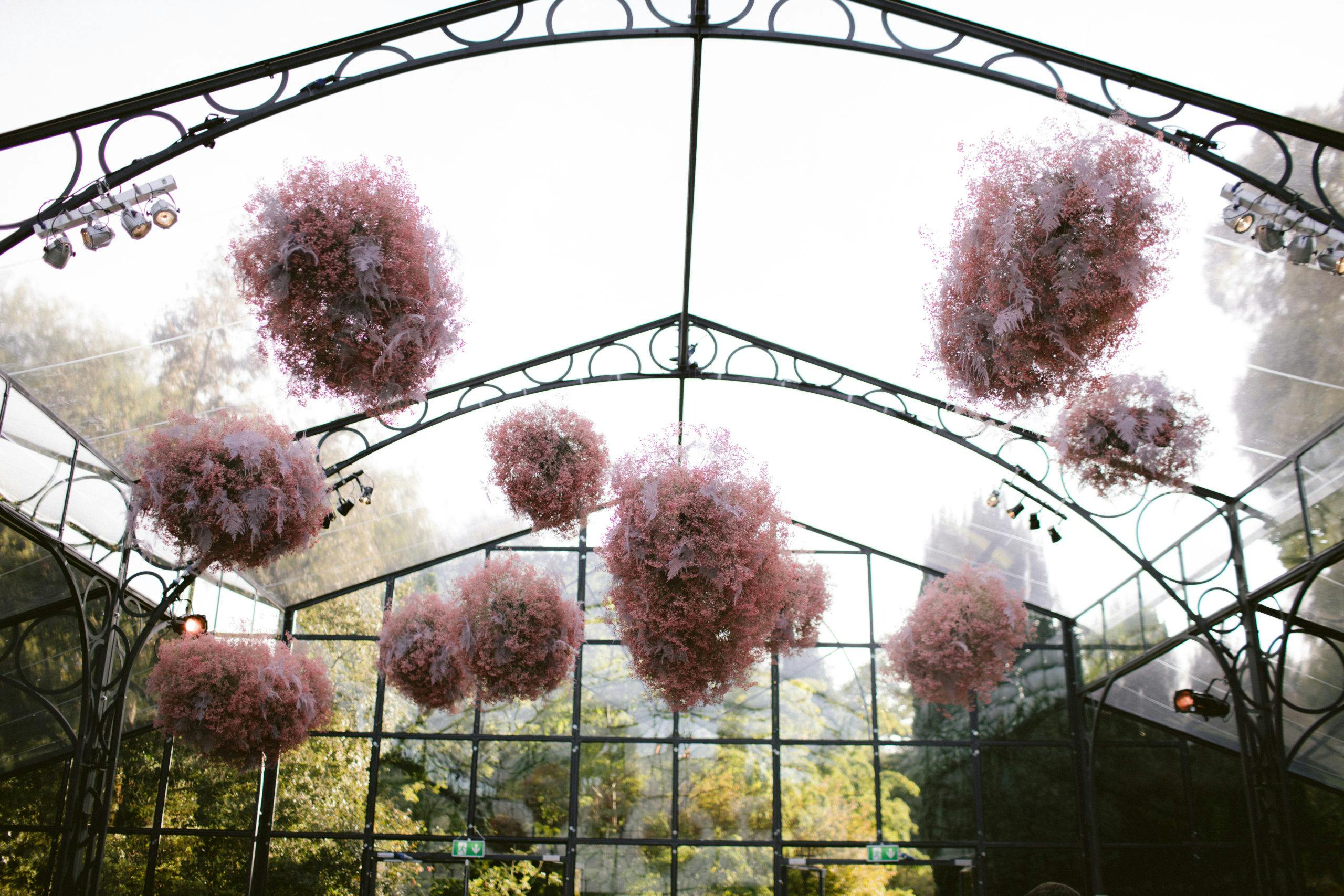 Glass Orangery-Style Wedding Tent with Pink Clouds of Baby’s Breath Suspended from Ceiling | PartySlate