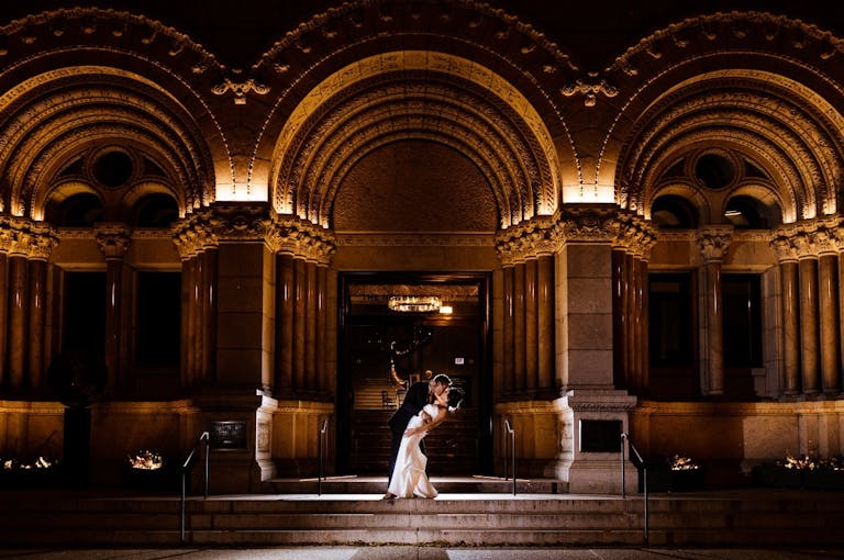Couple Kiss in Front of Dramatic Curved Arches of The Newberry Library, a Unique Chicago Wedding Venue